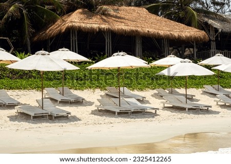 Similar – Image, Stock Photo Umbrellas and empty deckchairs collected on the beach shore in summer.
