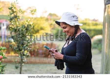 Latina woman with sombrero very happy looking at her cell phone Stok fotoğraf © 