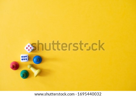 Chess pieces, game chips, Lotto barrels, draughts and playing cubes laid on a yellow background: entertainment, games at home for the whole family, the concept of table games. Board game. Board games