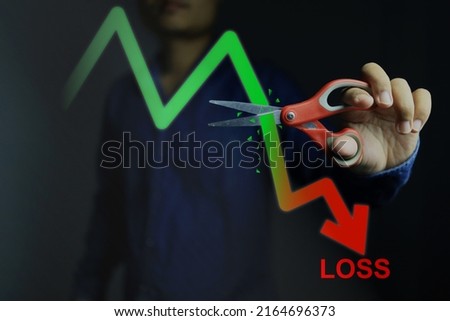 Investors decide to use scissors to cut or eliminate the loss portion of the red chart to maintain costs or prevent further losses in the stock market. cut loss concept. Stockfoto © 