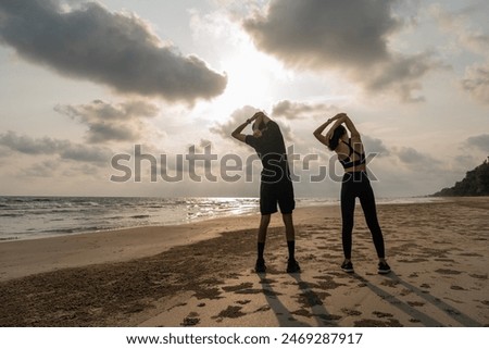 Foto Bild Schlanke Frau dehnt sich beim Training an der Strandpromenade