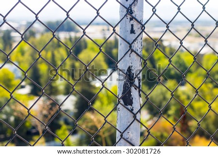 Fence post overlooking the suburbs. Selective focus