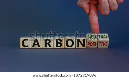 From carbon positive to neutral. Hand flips cubes and changes words 'carbon positive' to 'carbon neutral'. Beautiful white background, copy space. Business, ecological and carbon neutral concept.