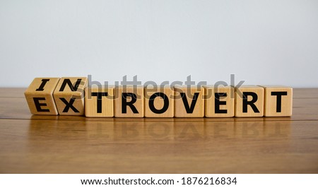Introvert or extrovert symbol. Fliped cubes and changed the word 'introvert' to 'extrovert'. Beautiful wooden table, white background, copy space. Psychological and Introvert or extrovert concept. Foto stock © 