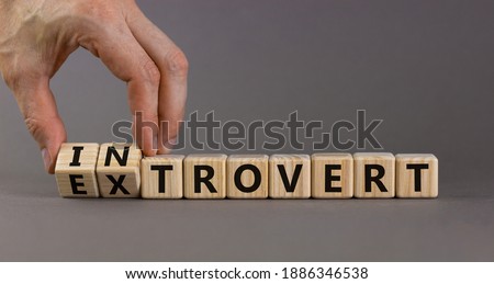 Introvert or extrovert symbol. Hand turns cubes and changes the word 'introvert' to 'extrovert'. Beautiful grey background, copy space. Psychological and Introvert or extrovert concept. Foto stock © 