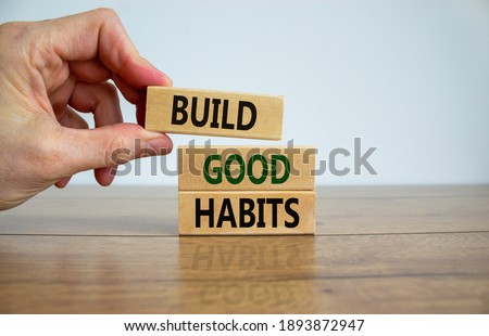 Build good habits symbol. Wooden blocks with words 'build good habits'. Male hand. Beautiful wooden table, white background, copy space. Business, psychological and build good habits concept. Foto d'archivio © 