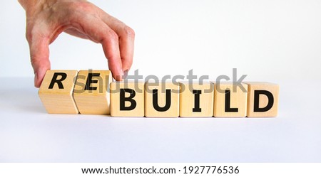 Time to rebuild symbol. Businessman turns wooden cubes and changes the word 'build' to 'rebuild'. Beautiful white background. Business, build or rebuild concept. Copy space.