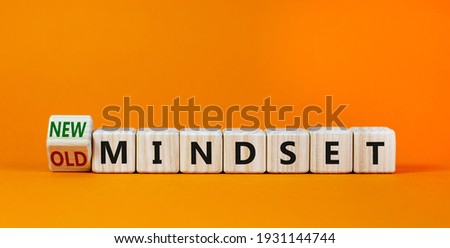 New vs old mindset symbol. Turned the wooden cube and changed words 'old mindset' to 'new mindset'. Beautiful orange background. Business, new or old mindset concept. Copy space.