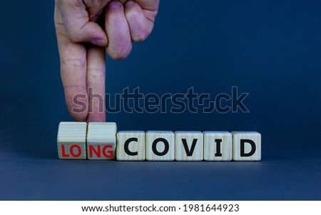 Long covid symbol. Doctor turnes wooden cubes and changes words 'covid' to 'long covid'. Beautiful grey background, copy space. Medical, covid-19 pandemic long covid concept.