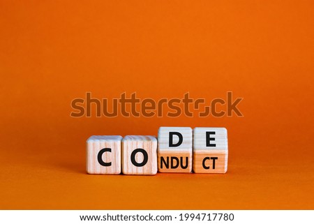 Code of conduct symbol. Turned the wooden cube and changed the word code to conduct. Beautiful orange background. Business and code of conduct concept. Copy space. Сток-фото © 