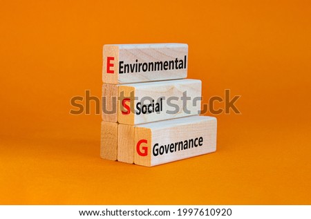 ESG environmental social governance symbol. Wooden blocks with words ESG environmental social governance. Orange background. Business and ESG environmental social governance concept. Copy space.