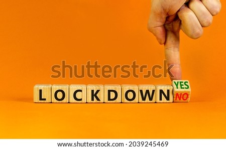End of the covid-19 lockdown symbol. Doctor turns a cube and changes words 'lockdown yes' to 'lockdown no'. Beautiful orange background, copy space. Covid-19 pandemic lockdown concept.