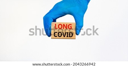 COVID-19 pandemic long covid symbol. Doctor hand in blue glove holds wooden blocks with words long covid, beautiful white background. Medical, COVID-19 pandemic long covid concept.