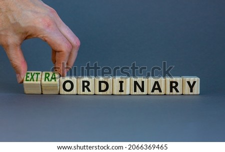 Ordinary or extraordinary symbol. Businessman turnes wooden cubes and changes words 'Ordinary extraordinary'. Beautiful grey background. Business, ordinary or extraordinary concept. Copy space. Stockfoto © 