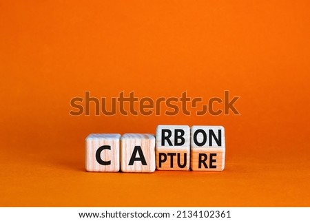 Carbon capture symbol. Turned wooden cubes and changed the concept word Carbon to Capture. Beautiful orange table orange background. Business ecological carbon capture concept. Copy space. Foto d'archivio © 
