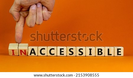 Accessible or inaccessible symbol. Businessman turns wooden cubes, changes the word Inaccessible to Accessible. Beautiful orange background, copy space. Business, accessible or inaccessible concept. Сток-фото © 