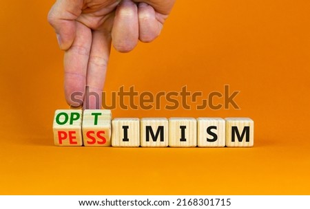 Pessimism or optimism symbol. Businessman turns cubes and changes the word 'pessimism' to 'optimism'. Beautiful orange table, orange background. Business, optimism or pessimism concept. Copy space. Сток-фото © 