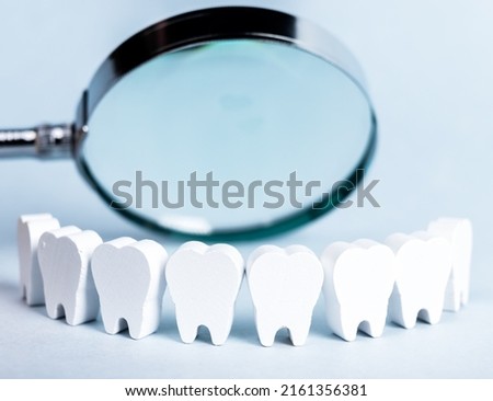 Teeth in smile form with magnifying glass. Dental checkup, tooth, gums, mouth examination concept. Routine visit to dentist and checking for cavity, plaque, periodontal disease. High quality photo 商業照片 © 