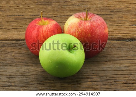 Three apples on  wood background.