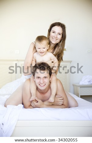 young happy family having fun in bedroom