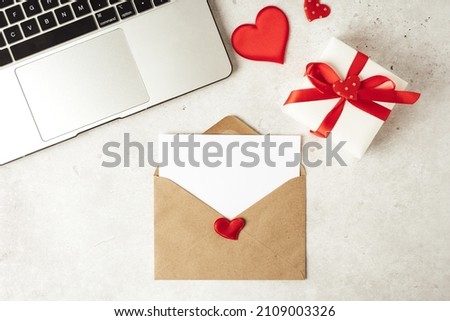 Red paper envelope with blank paper white note mockup. Flat lay of gray working table background with Valentine gift, letter, heart shape, laptop and decoration. Top view, mock up greeting card Сток-фото © 