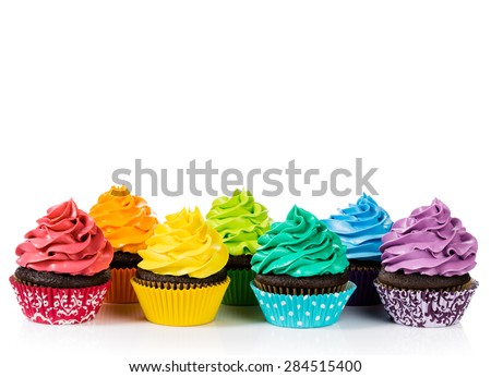 Chocolate cupcakes in rows with colorful icing on a white background.
