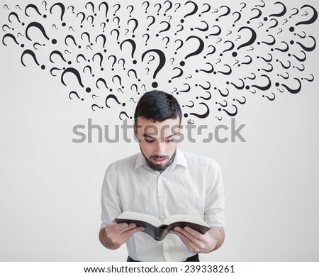 Human emotion facial expression.Surprised man reading a book. The guy has a lot of questions