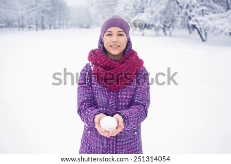 The girl in the lilac hat purple jacket and pink scarf. Woman in a park in winter having fun