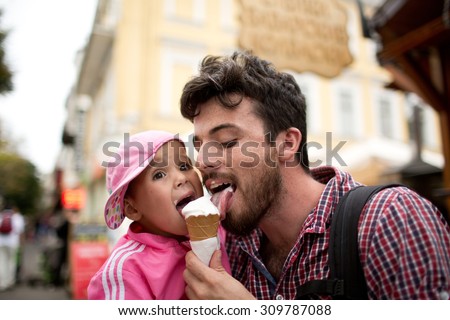 Dad and child are eating ice creams together