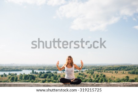 girl practicing yoga on roof. Yoga in the park