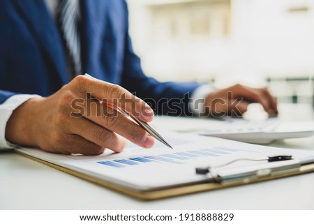 An Asian male finance worker or accountant is reviewing the investment results. To report at the meeting, audit ideas And investment results