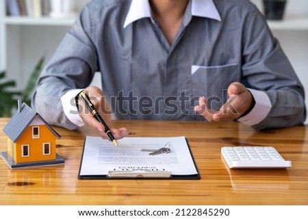 Real estate agents offer prices. and model homes, handing out keys, consulting with customers to decide how to sign a home insurance contract about mortgage and home insurance offers Foto stock © 