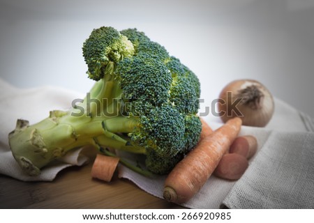 broccoli, carrots and onion on linen white rug