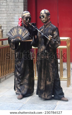 TIANJIN, CHINA - JUNE 25, 2013: two street artists in specific costums and with painted faces make performance in Tianjin, China on 25th June 2013