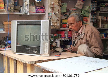DELHI, INDIA - FEBRUARY 18, 2015: man repairs tv in repair shop