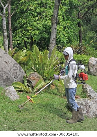 KUALA LUMPUR, MALAYSIA - APRIL 2, 2015: lawn mower man is doing his work in botanical garden of Kuala Lumpur, Malaysia