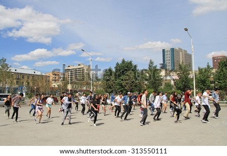 ULAANBAATAR, MONGOLIA - JULY 8, 2015: big group of people is repeating common dance on the square in Ulaanbaatar