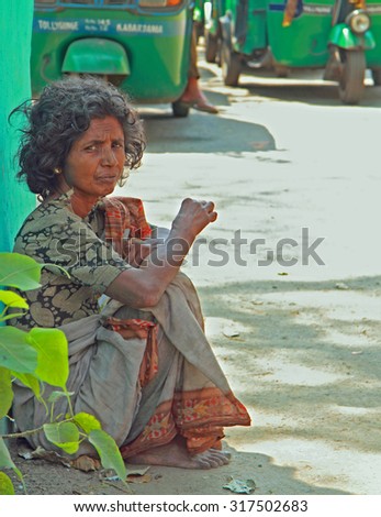 KOLKATA, INDIA - MARCH 15, 2015: poor woman is sitting on the pavement in Kolkata, India