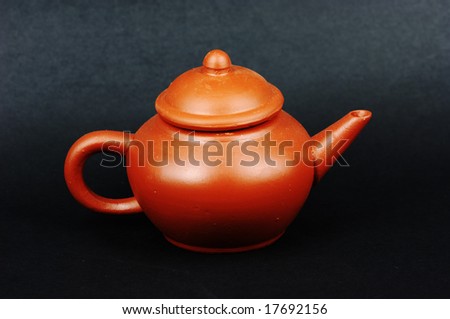 Red clay Chinese tea pot on black background