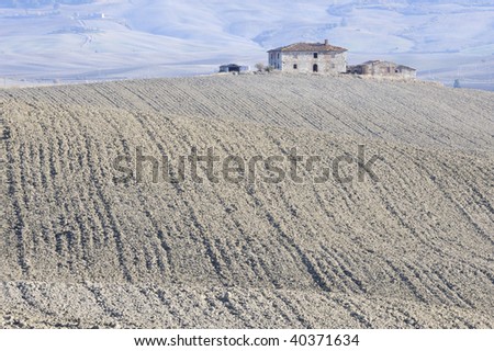 Villa and farm among ploughed fields in Tuscany, Italy