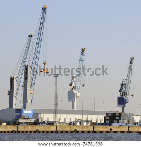 Idle cranes in hard times in harbor against clear blue sky, Hamburg, Germany