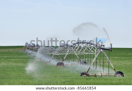 Mobile irrigation machine in action spraying water on crops