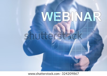 Businessman pressing button on touch screen interface and select Webinar. Business, internet, technology concept.