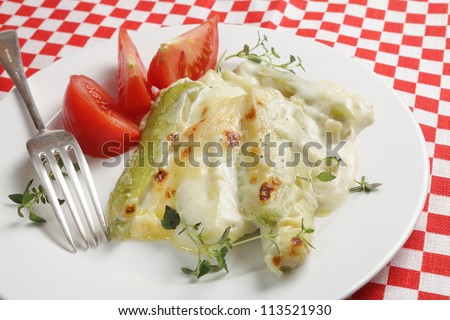 Courgettes baked in a garlic flavoured bechamel sauce topped with cheddar cheese and garnished with thyme,