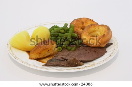 Traditional English Sunday dinner: Roast beef and yorkshire pudding, with potatoes and green beans.