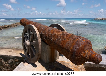 An old ship\'s cannon recovered from the sea bed on a wall near the harbour, Fregate, Seychelles