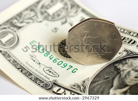 A British 50 pence piece on a US one dollar bill, the two are roughly equivalent in value in early 07.
