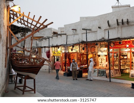 Lights come on in the tourist shops as evening falls over the Old Souq in Doha, Qatar.