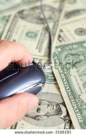 Using a computer mouse on an array of US banknotes, symbolic of making or spending money using computers