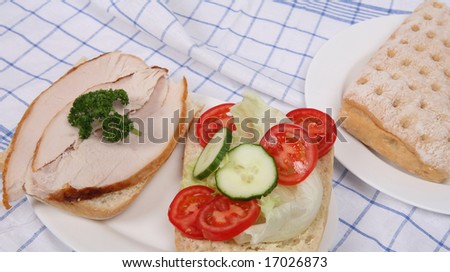 An open ciabatta cold turkey breast and salad sandwich.